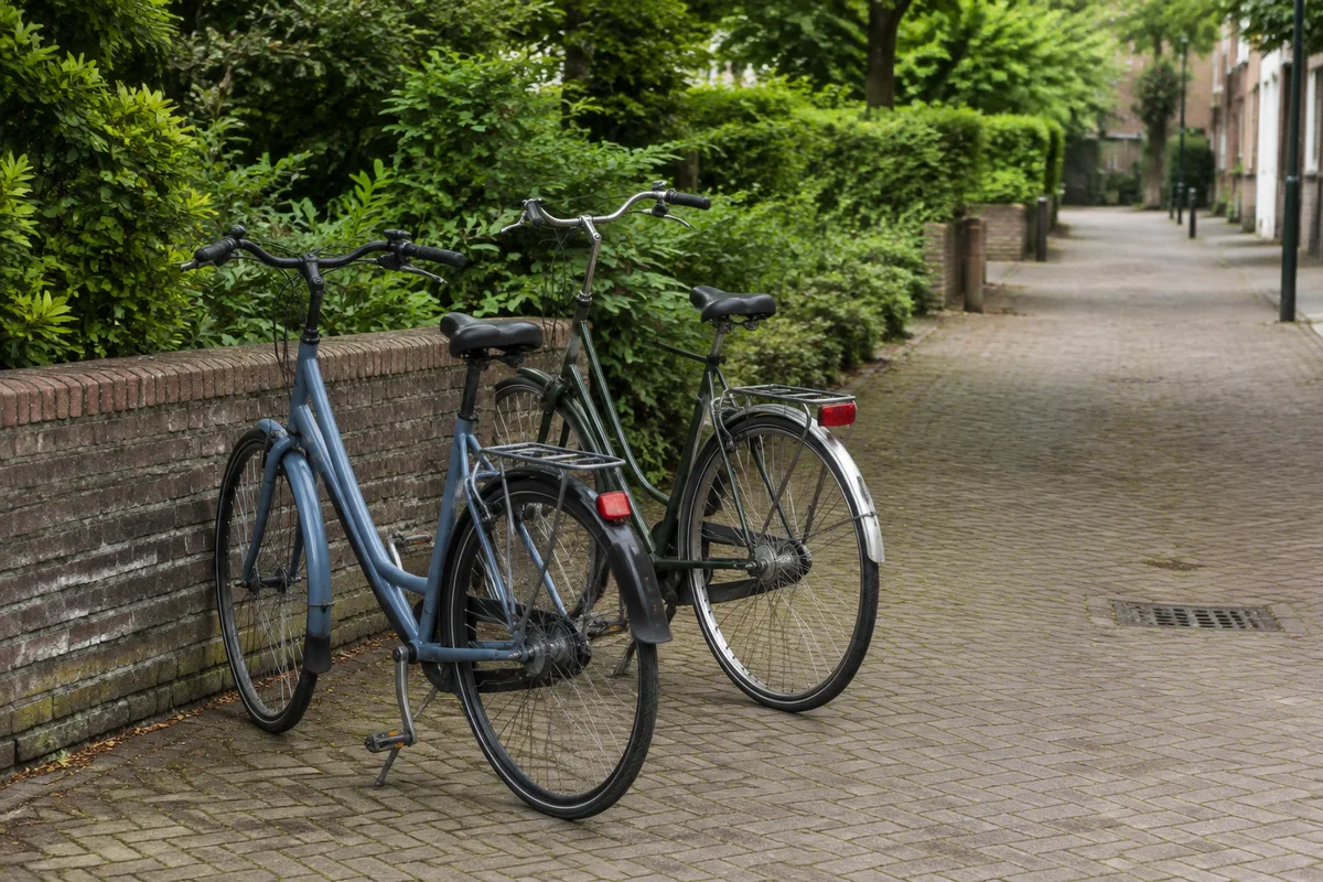 twee fietsen naast elkaar bij een lage tuinmuur